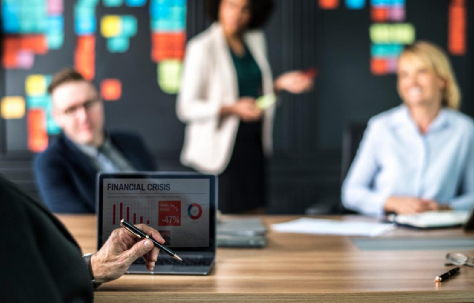 Organized desk workspace with financial planning materials and laptop for focused remote learning